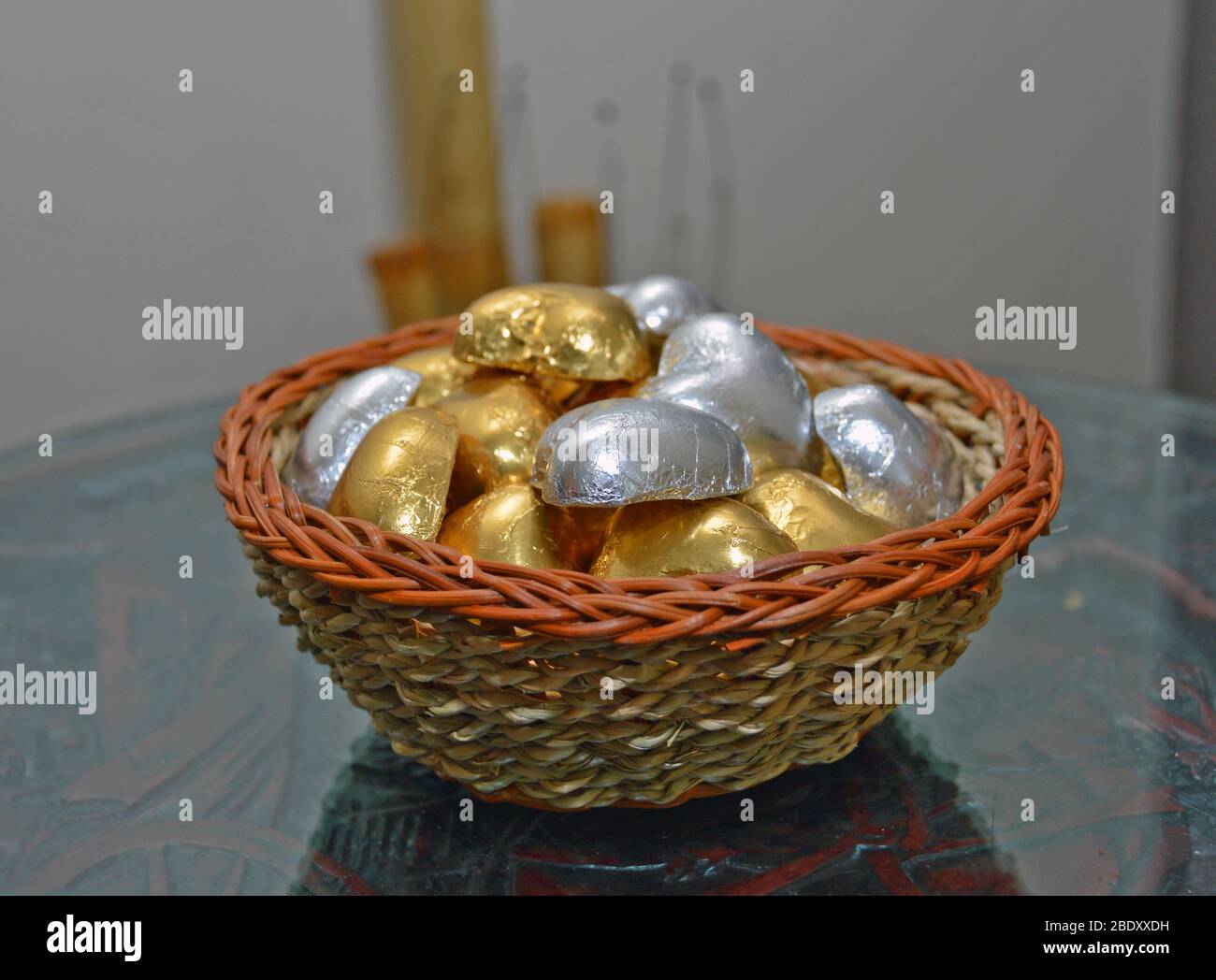 Wicker bowl decorative item filled with various shiny stones, interior decor ideas for massage parlor, great for oriental therapy sessions Stock Photo