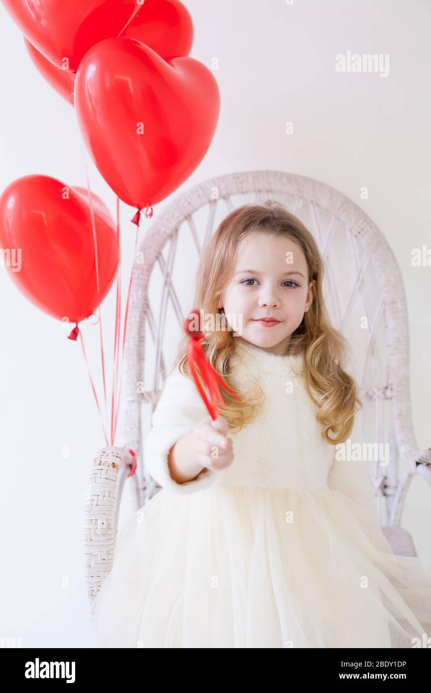 Beautiful girl with red balloons sitting in a white chair Stock Photo ...
