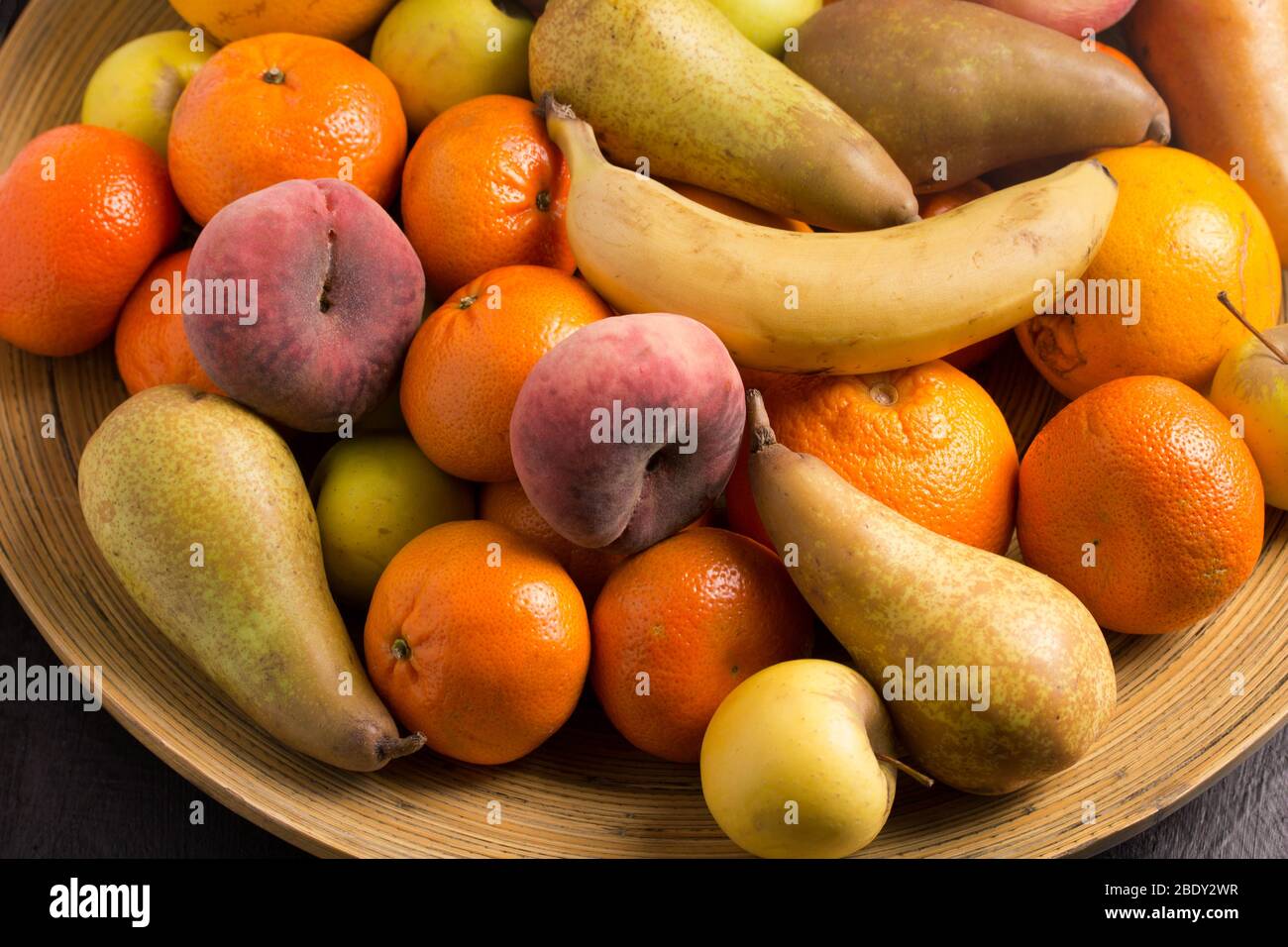 Assorted whole fruit in large bamboo fruit bowl photo of pears, flat