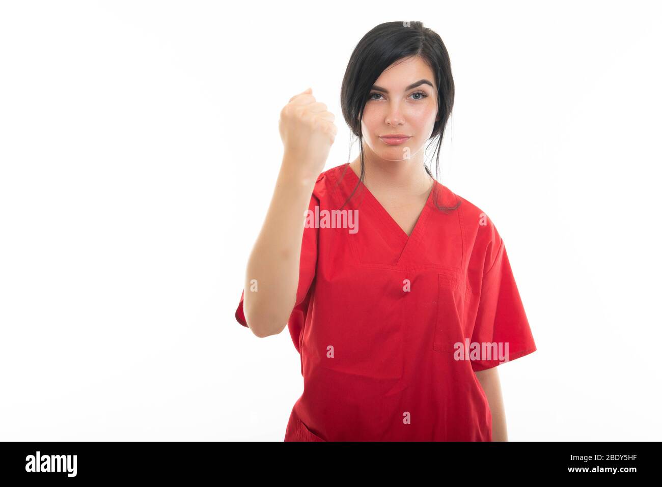 Portrait of young attractive female nurse showing fist like fighting isolated on white background with copy space advertising area Stock Photo