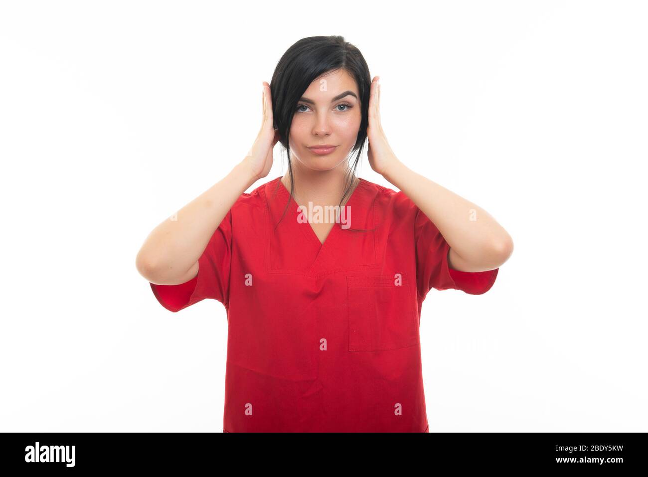 Portrait of attractive female nurse covering ears like deaf gesture on