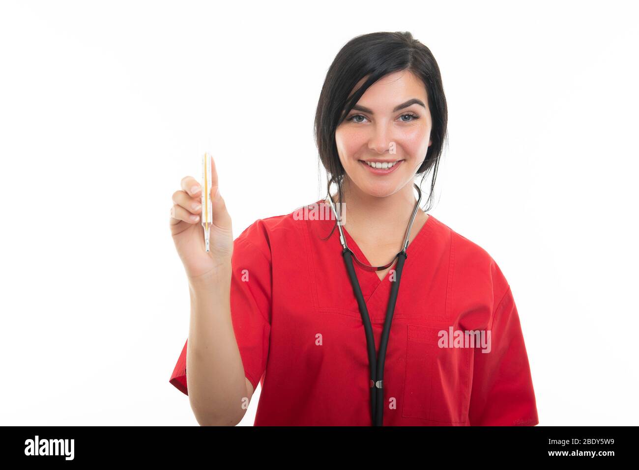 Portrait of young attractive female nurse showing thermometer isolated on white background with copy space advertising area Stock Photo