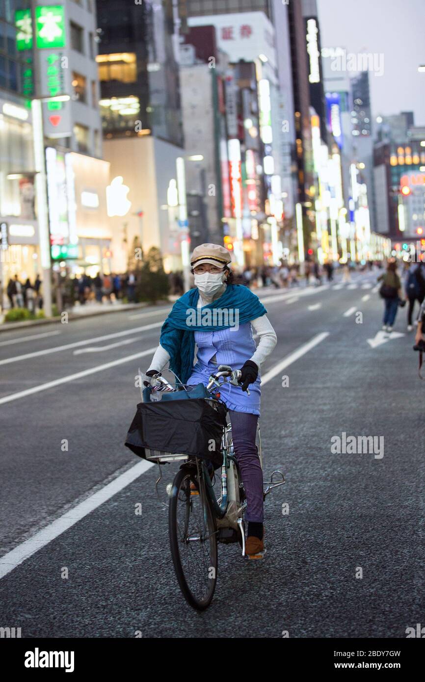 Travellers take precautions by wearing face masks ,tokyo street,preventing corona virus,japanese street,tokyo,bovid 19 protection,health precautions Stock Photo