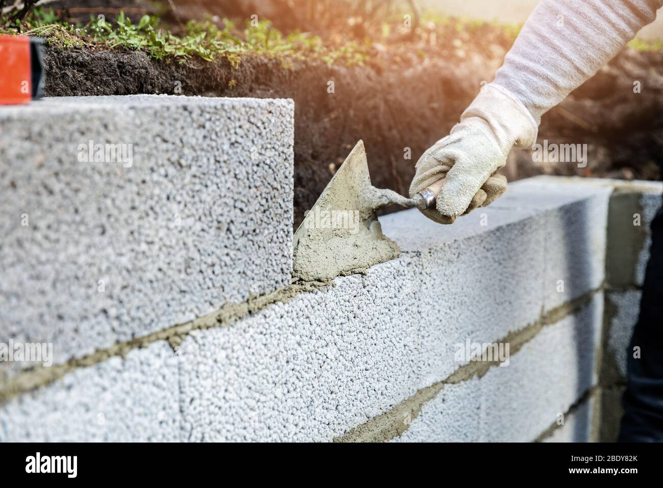 wall construction from expanded clay blocks, applying mortar with trowel Stock Photo