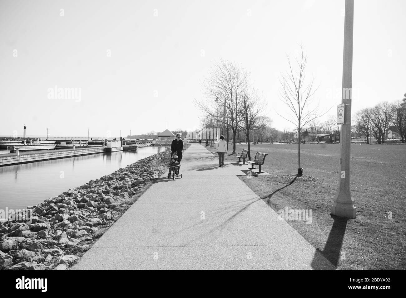 OAKVILLE, ONTARIO, CANADA - APRIL 28, 2020: PEOPLE GO FOR A WALK ALOING THE WATERFRONT DURING COVID-19 PANDEMIC. Stock Photo