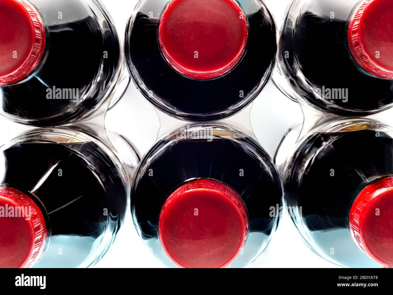 Horizontal close-up shot of a six-pack of generic soft drinks with red caps from above.  White background. Stock Photo