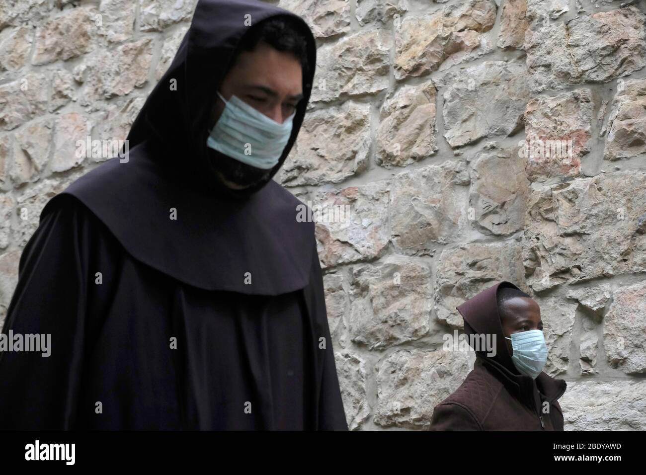 Franciscan monks wearing protective mask due to the COVID-19 coronavirus pandemic walking along the Via Dolorosa, to mark Good Friday in Jerusalem, Israel. Stock Photo