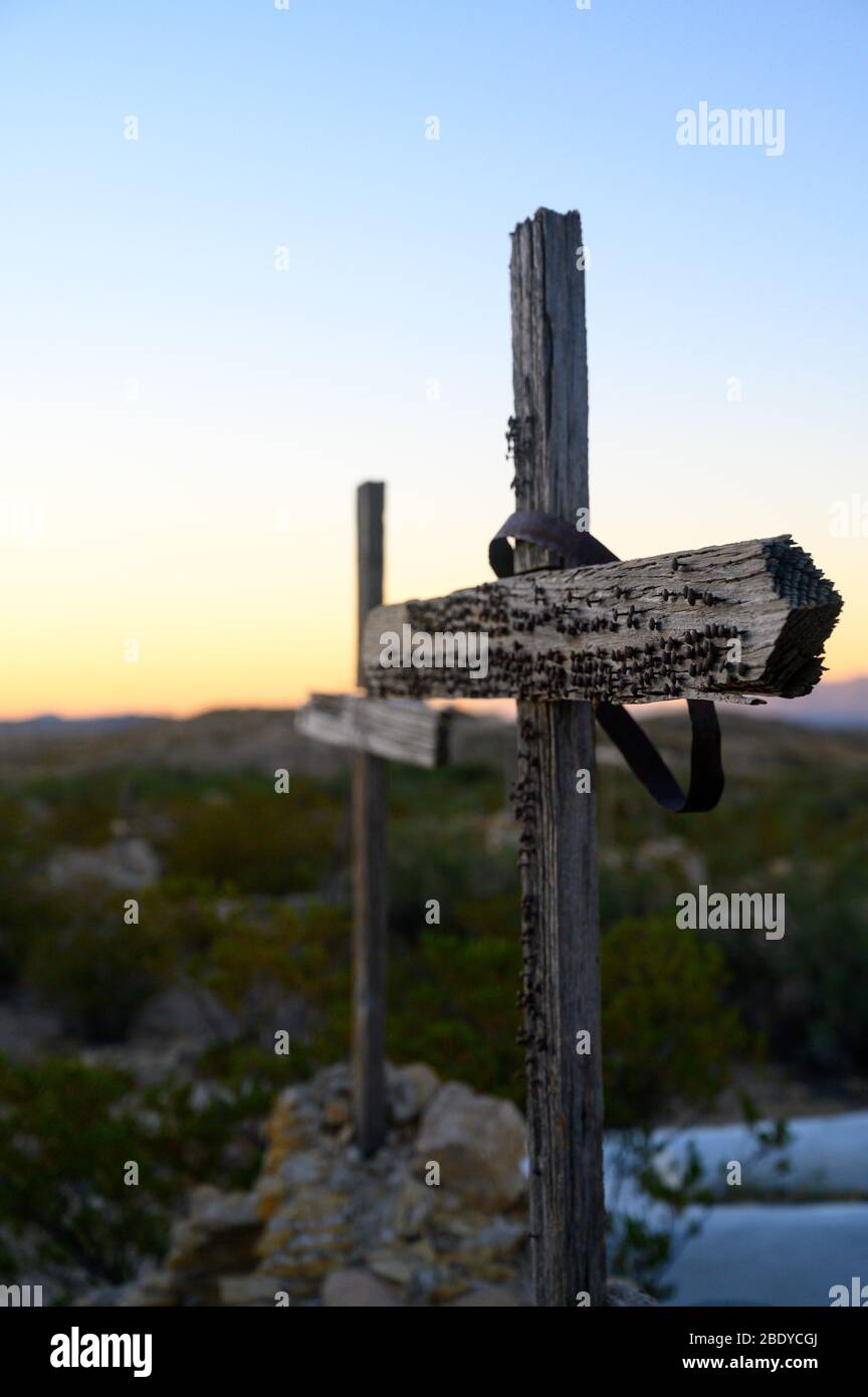Two wooden crosses with nails in them mark graves in the Terlingua Cemetery in West Texas, where the graves are marked by handmade embellishments. Stock Photo