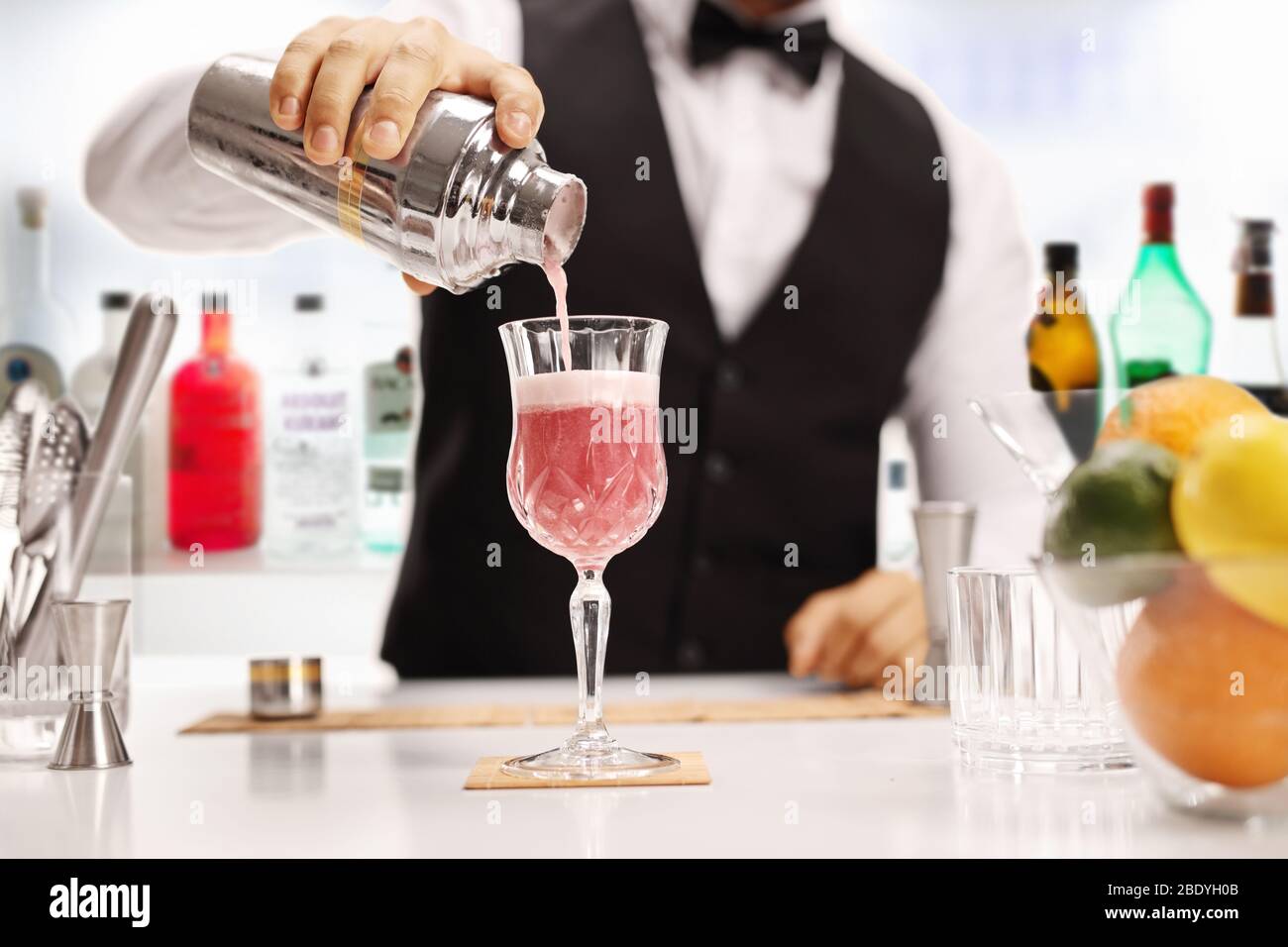 Bartender pouring a cocktail in a glass in a bar Stock Photo