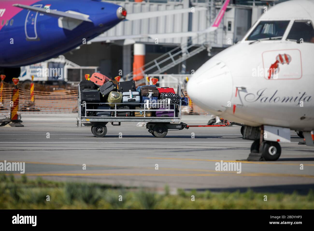 Otopeni, Romania - April 9, 2020: Luggages on baggage carrier on the Henri Coanda International Airport taxiway. Stock Photo