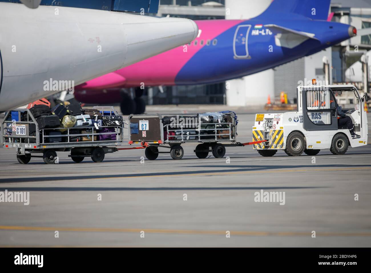 Otopeni, Romania - April 9, 2020: Luggages on baggage carrier on the Henri Coanda International Airport taxiway. Stock Photo
