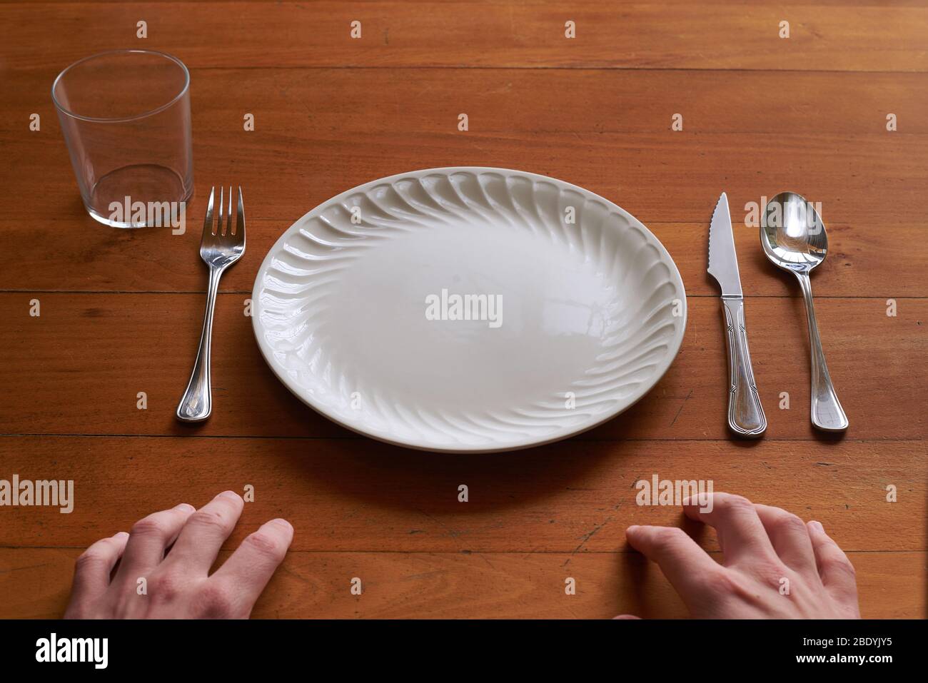 Point of view of a person about to eat on an empty porcelain plate Stock Photo