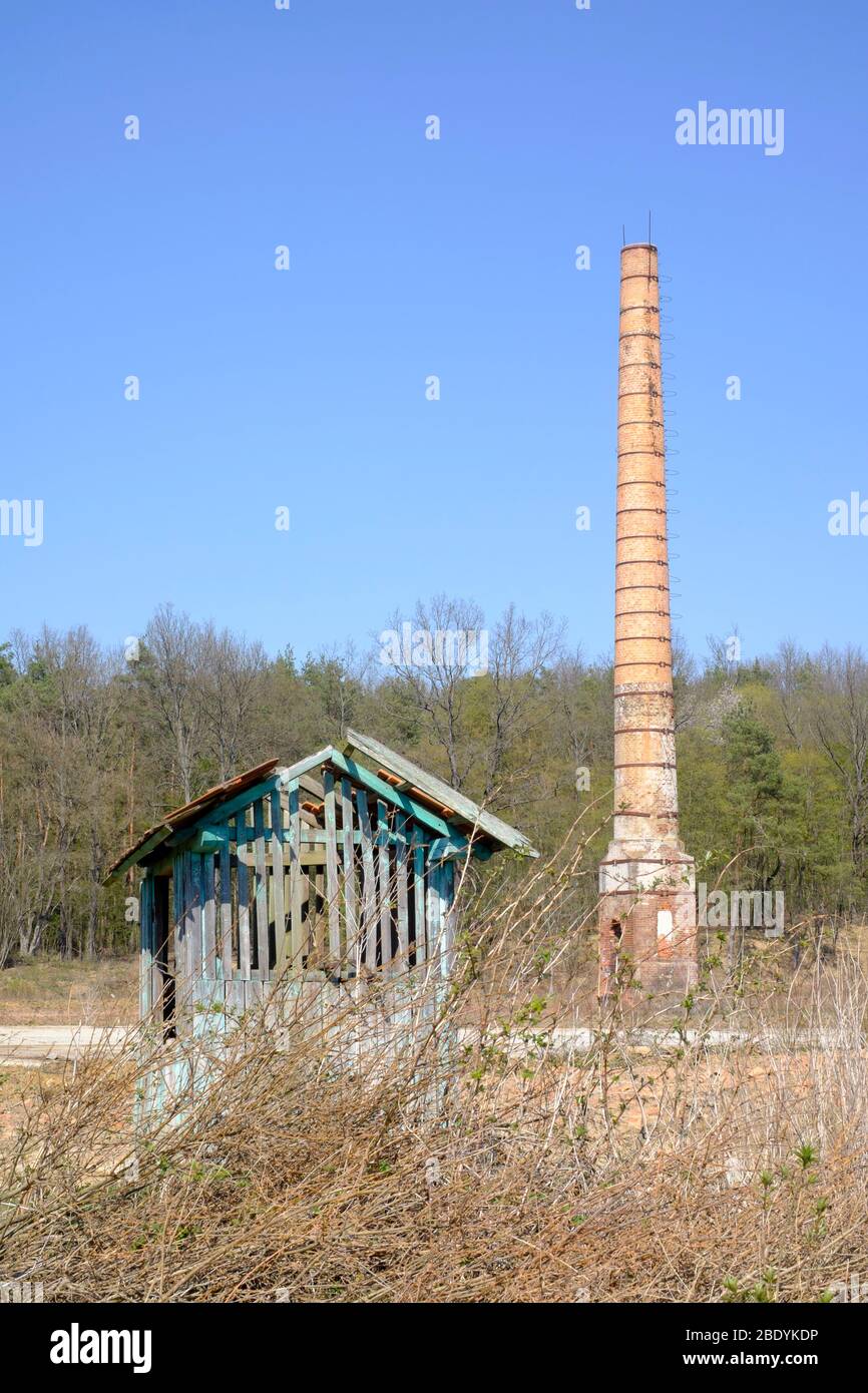 tall industrial chimney stack stands alone in the centre of an empty wasteland sole remnant of previous factory zala county hungary Stock Photo