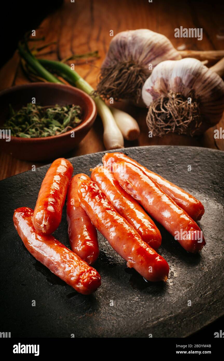 delicious and crispy little chorizo sausages on a hot platter Stock Photo