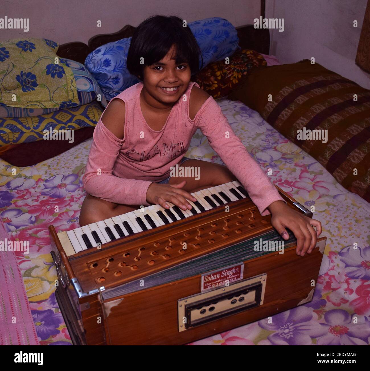 Front shot of an Indian girl playing harmonium Stock Photo