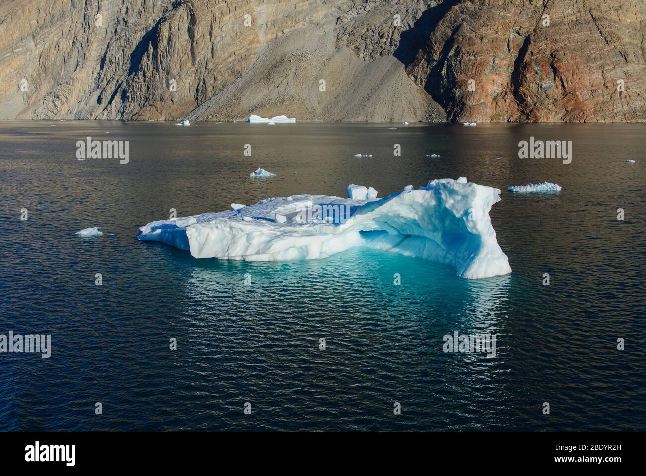 Greenland Coastal Rocks Greenland landscape with beautiful coloured rocks and iceberg Stock ...