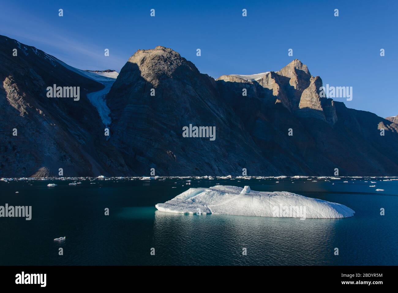 Greenland Coastal Rocks Greenland landscape with beautiful coloured rocks and iceberg Stock ...