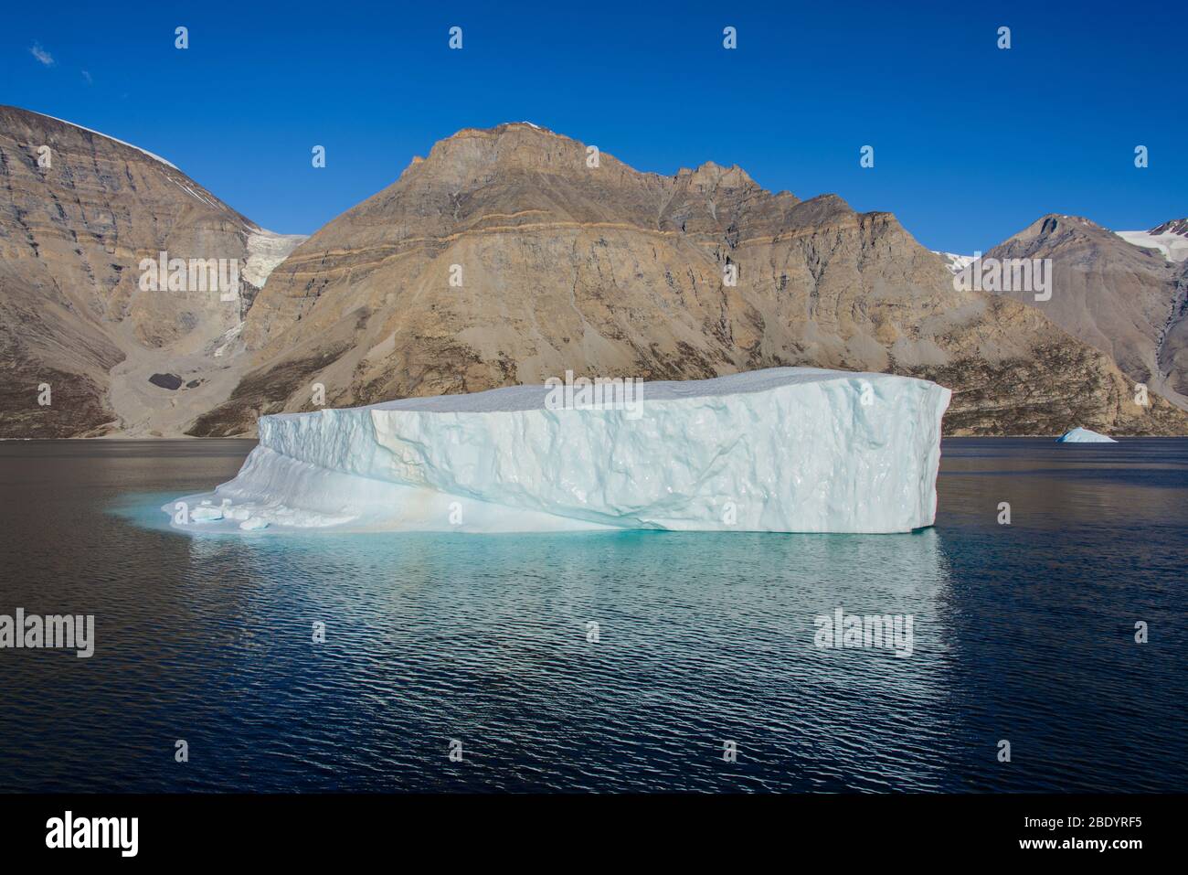 Greenland Coastal Rocks Greenland landscape with beautiful coloured rocks and iceberg Stock ...