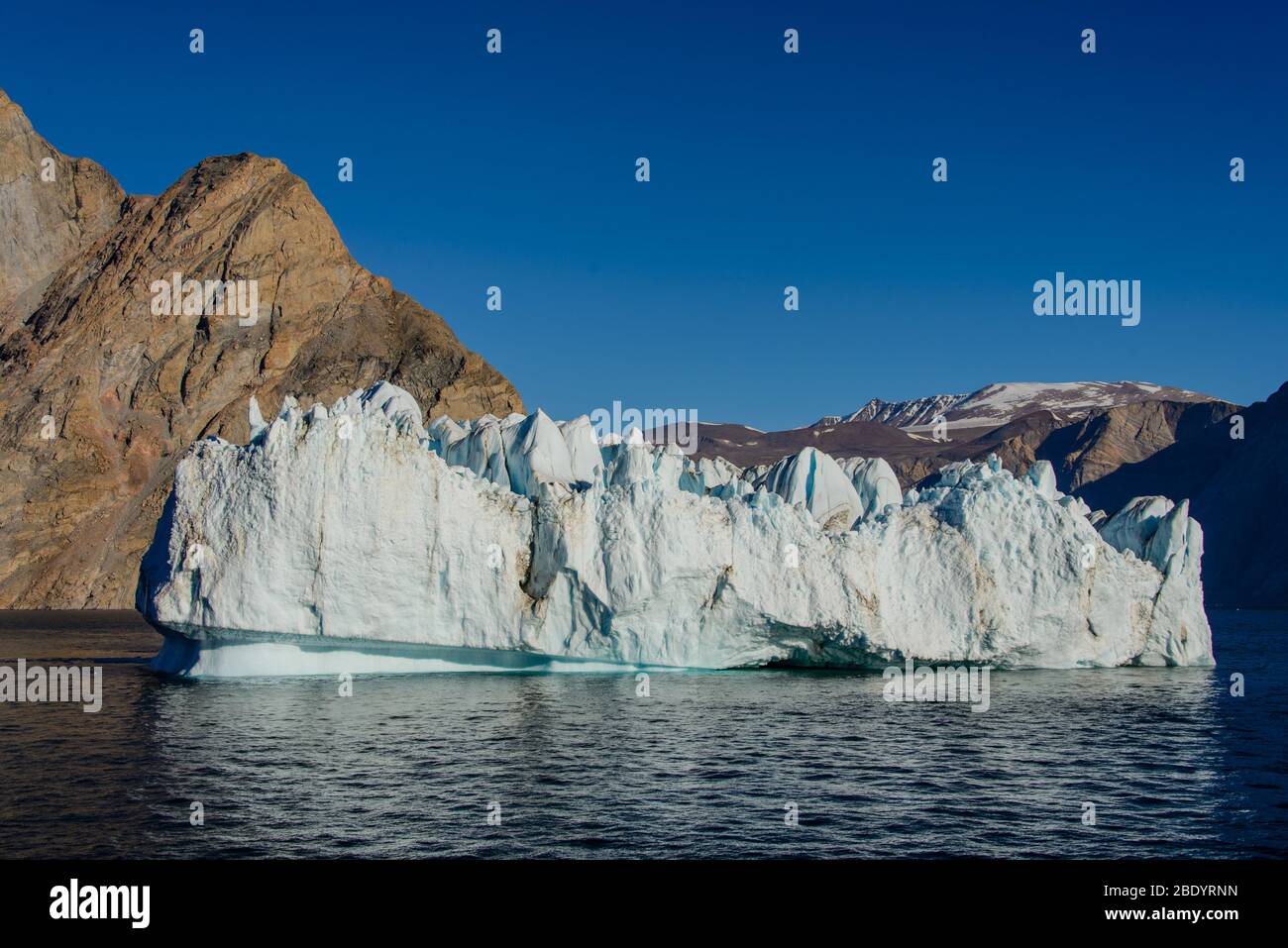 Greenland Coastal Rocks Greenland landscape with beautiful coloured rocks and iceberg Stock ...