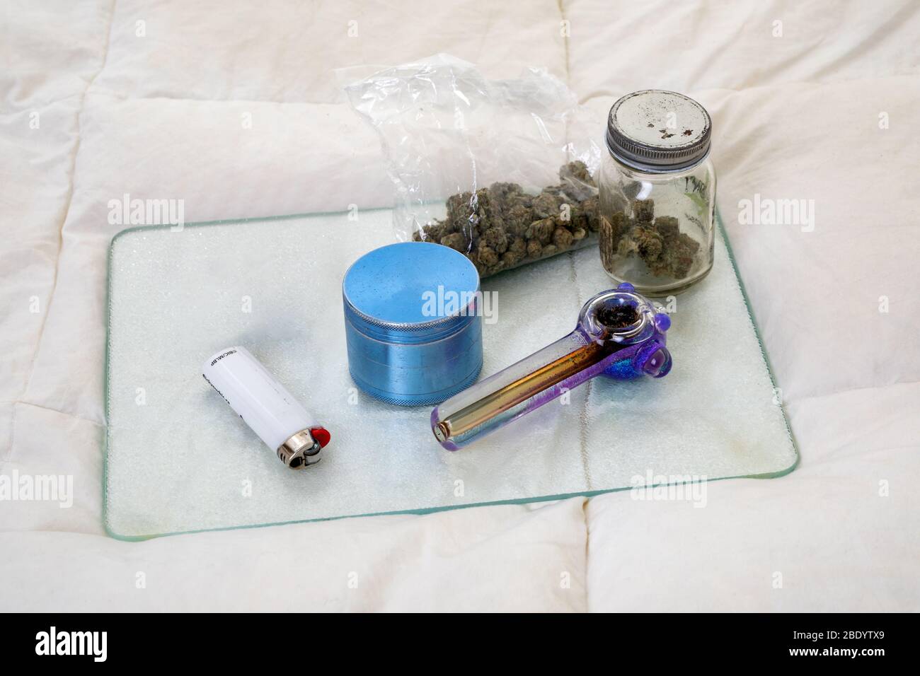 Assortment of Cannabis Paraphernalia and Dried Flower Buds Stock Photo