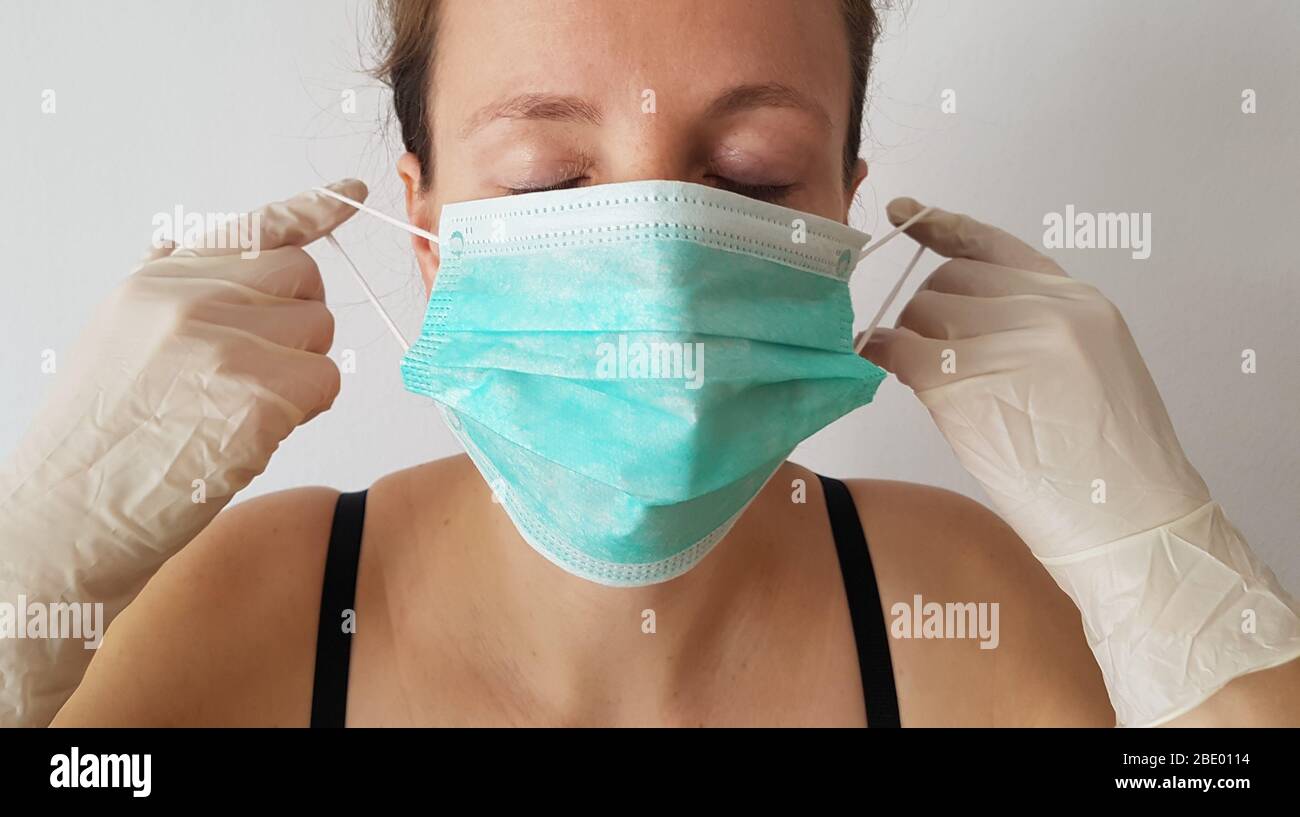 One person front view ( woman ) wearing / put on surgical mask or face mask & rubber gloves for infection protection of epidemic corona virus covid-19 Stock Photo