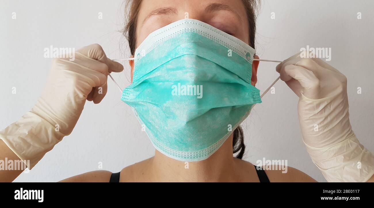 One person front view ( woman ) wearing / put on surgical mask or face mask & rubber gloves for infection protection of epidemic corona virus covid-19 Stock Photo