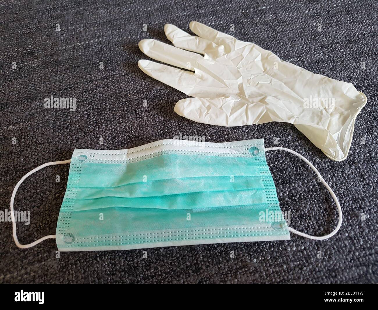 Surgical mask in green / face mask and latex hand rubber glove used in hospitals by doctors / nurse for protection like epidemic corona virus covid-19 Stock Photo