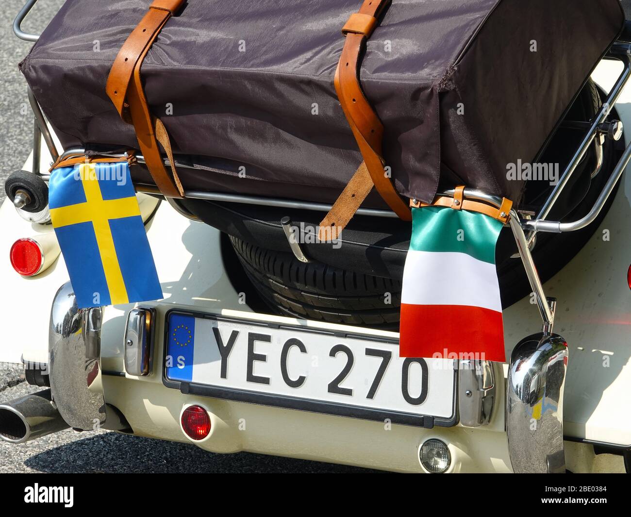 Suitcase loaded on rear pannier of a sportscar ready for travelling around the Swiss alps Stock Photo