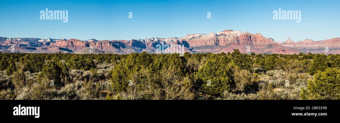 Panorama of the cliffs and towers of red and pink sandstone above the entrance to Zion Canyon of Zion National Park. Stock Photo