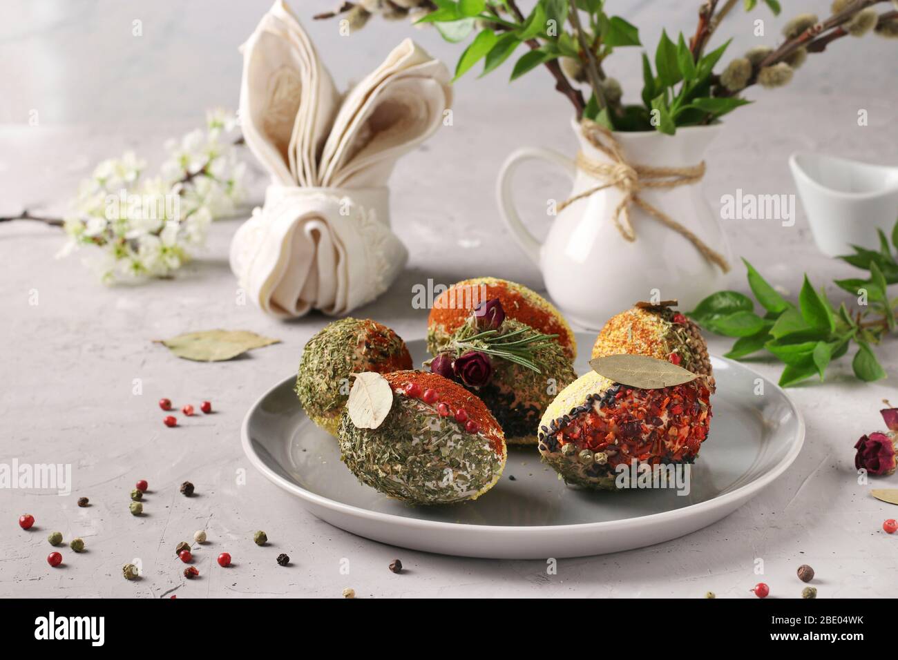 Easter eggs decorated with different spices and cereals without dyes and preservatives on a plate on a gray concrete background Stock Photo