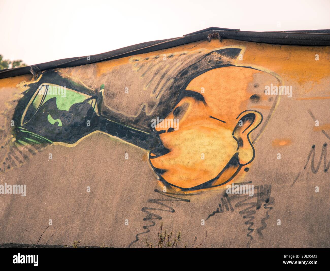 Portuguese graffiti art of a man drinking port out of a bottle Cais de Gaia, Porto Portugal Stock Photo