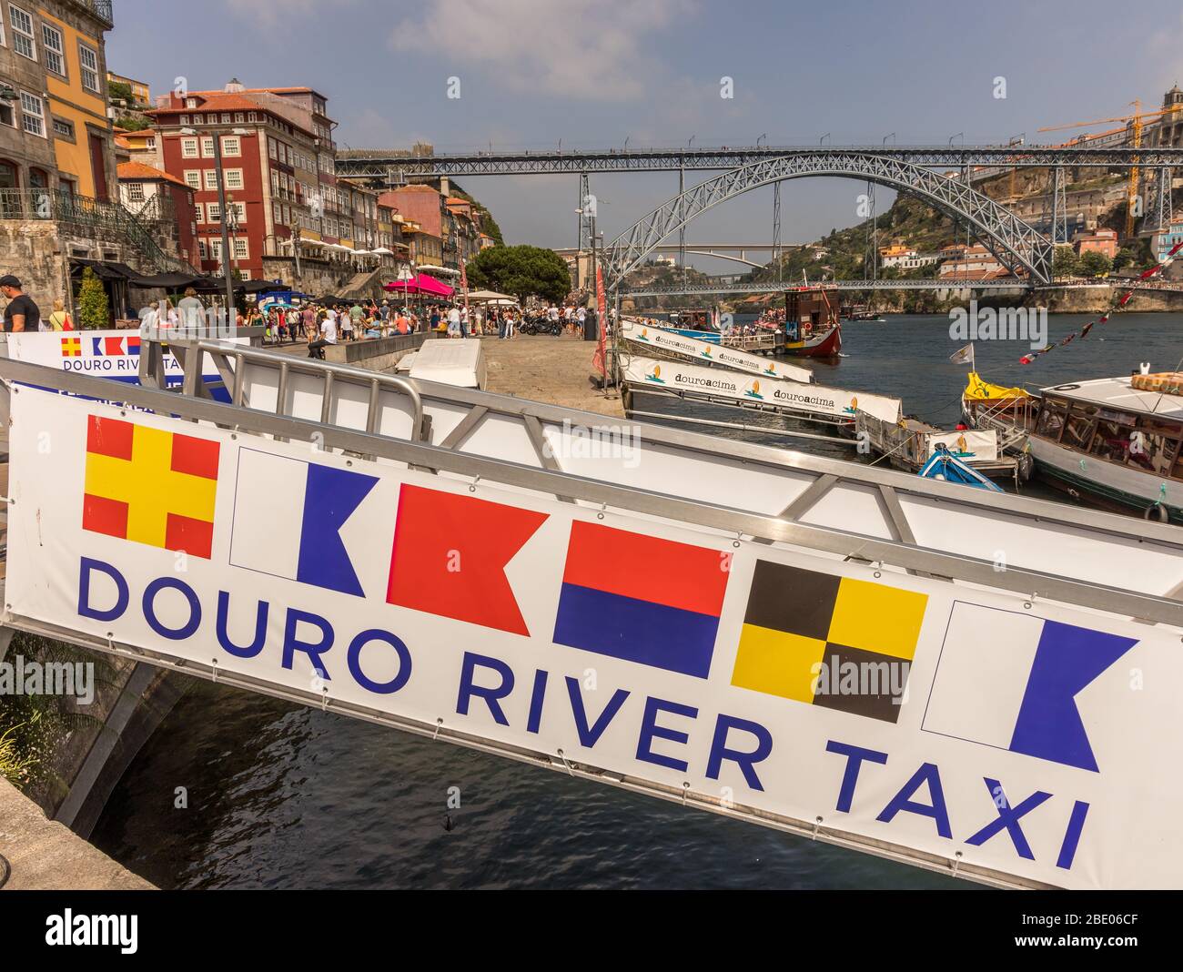 Douro River Taxi loading ramp and dock showing nautical flags RABELA (table), the river and bridge in Porto in background, Portugal Stock Photo