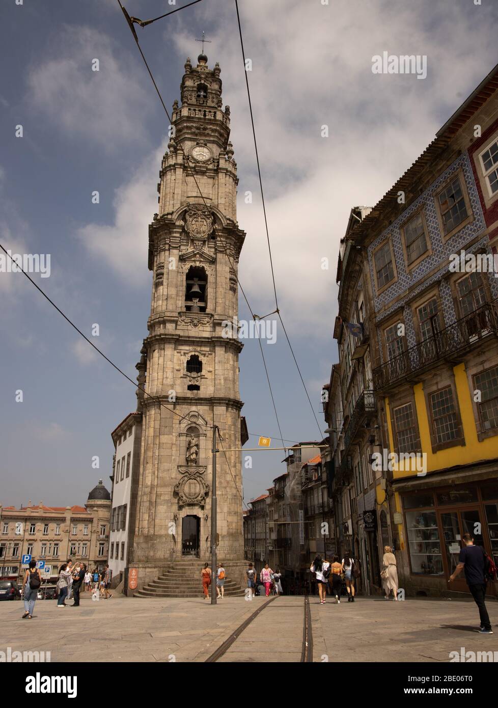 Tall bell tower of Torre dos Clérigos Church a Baroque church showing tram lines and street life Porto Portugal Stock Photo