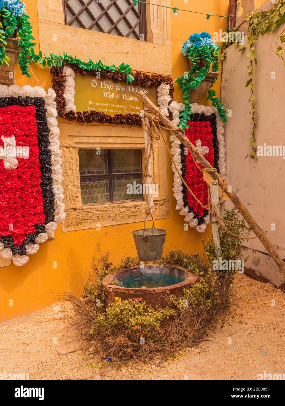 Colourful decorated courtyard with wall and shields made of flowers during traditional Festa dos Tabuleiros Festival of the Trays Tomar Portugal. Stock Photo