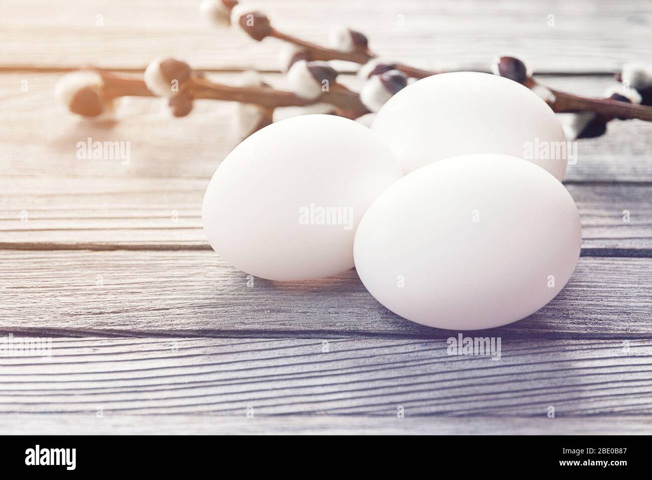white easter eggs with willow branches on wood background Stock Photo ...
