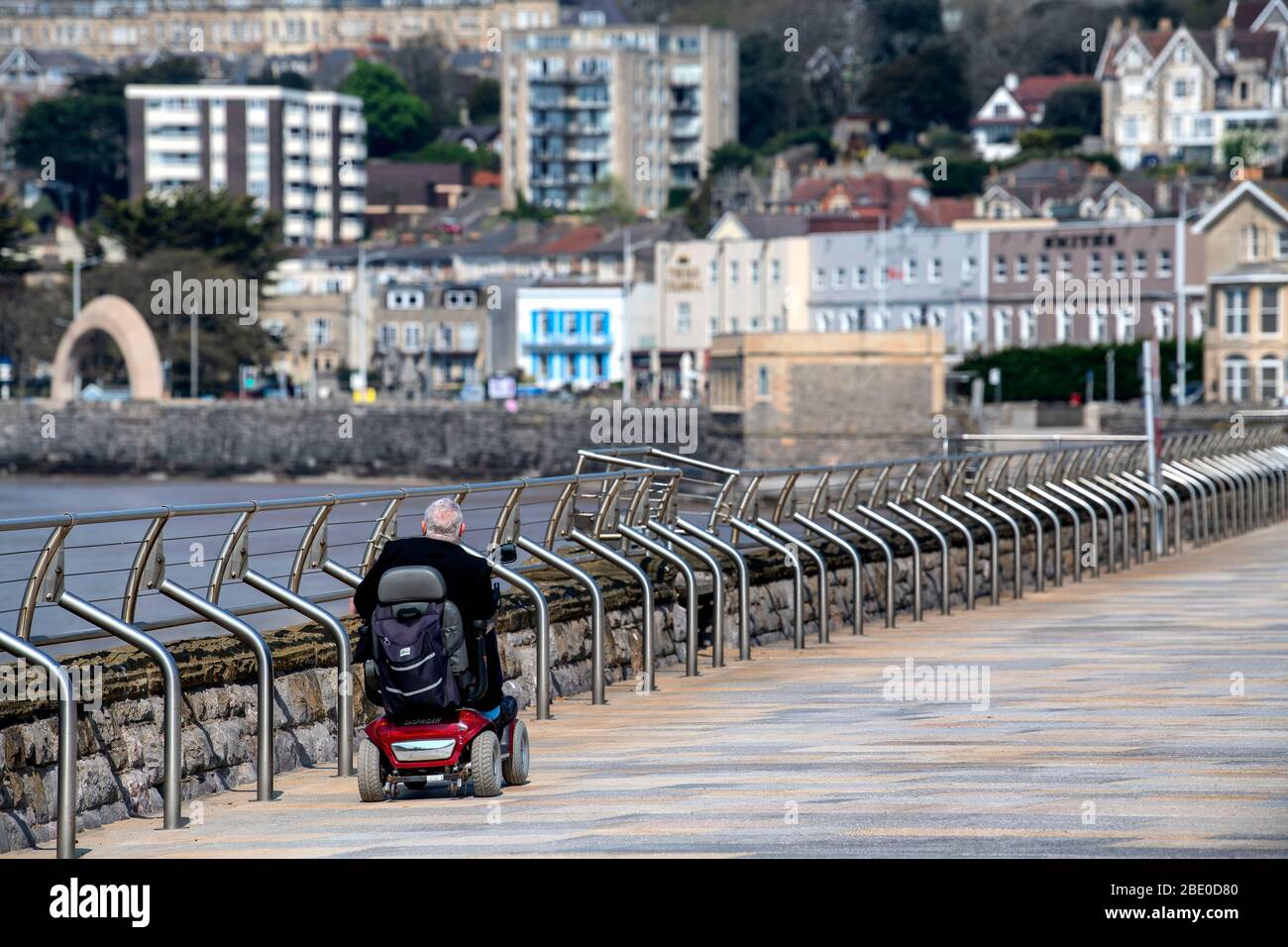 A man on a mobility scooter rides along Royal Parade past the Grand
