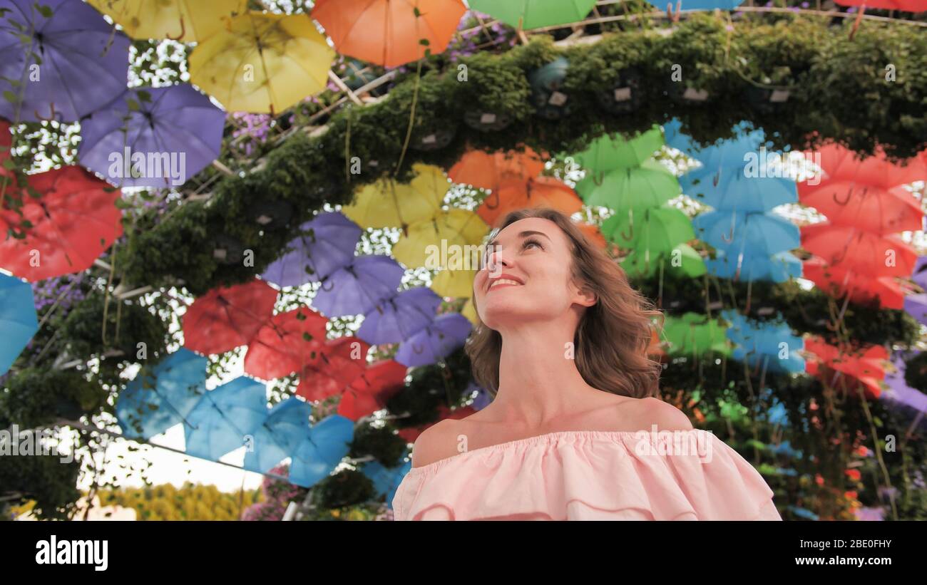Beautiful girl on the background of multi-colored umbrellas in the park of the city. Stock Photo