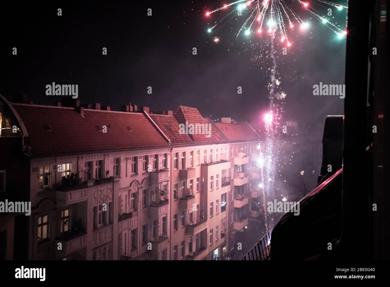 Home fireworks explode from balcony high in Berlin streets new year Stock Photo