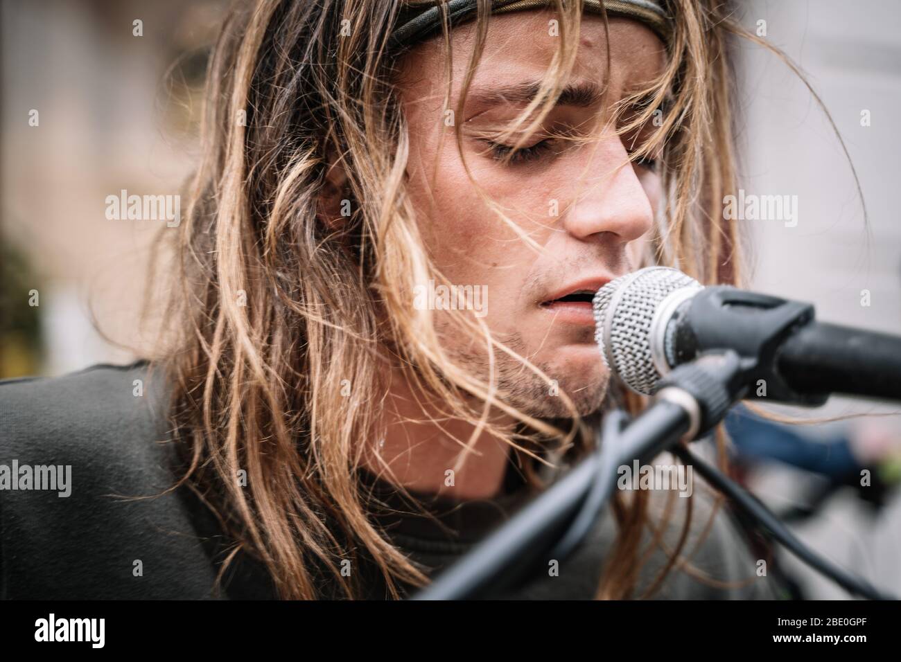 Detail of the face of a young rocker singing with emotion in the street with a microphone Stock ...