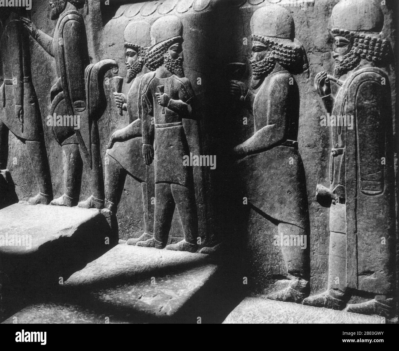 Tribute bearers in a relief along the northern staircase of the Council Hall (Tripylon), in the ancient Perisan capital of Persepolis, Iran, dating from about 500 BC. Stock Photo
