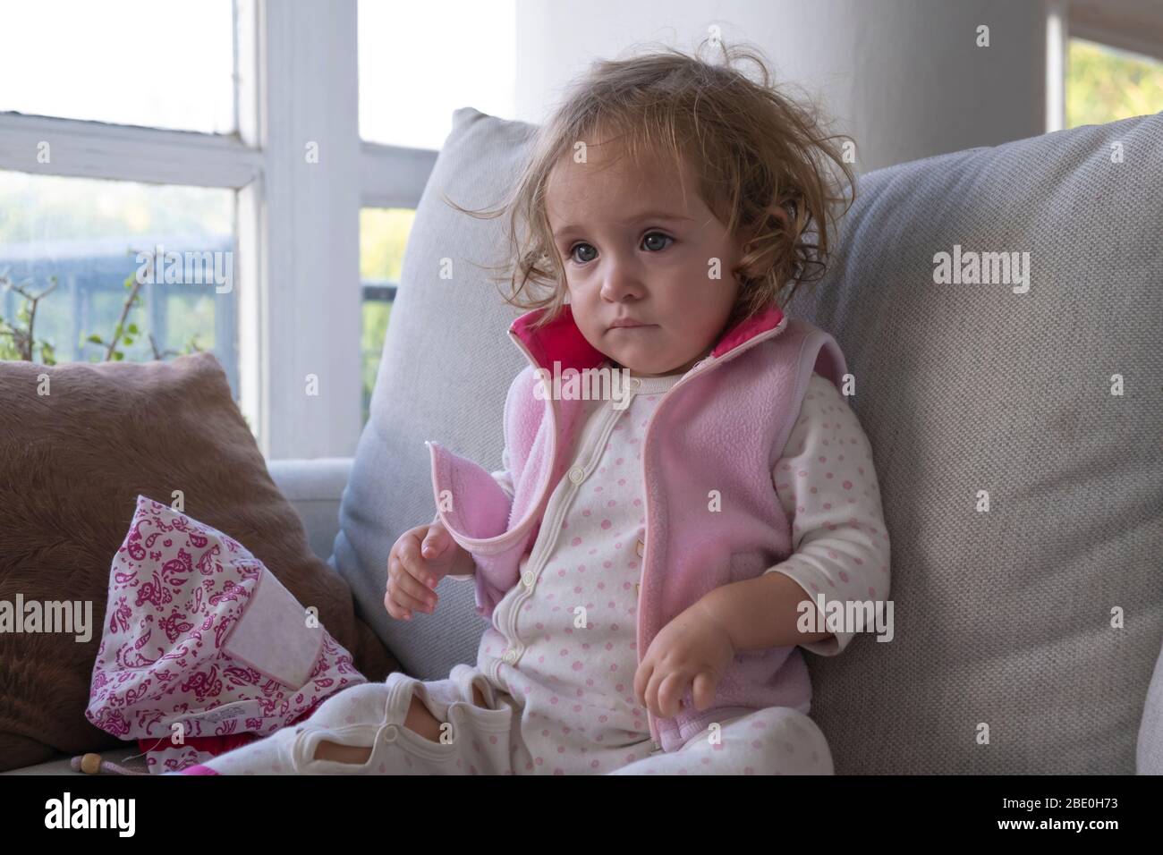 Little girl concentrate watching tv alone in her living room. Stock Photo