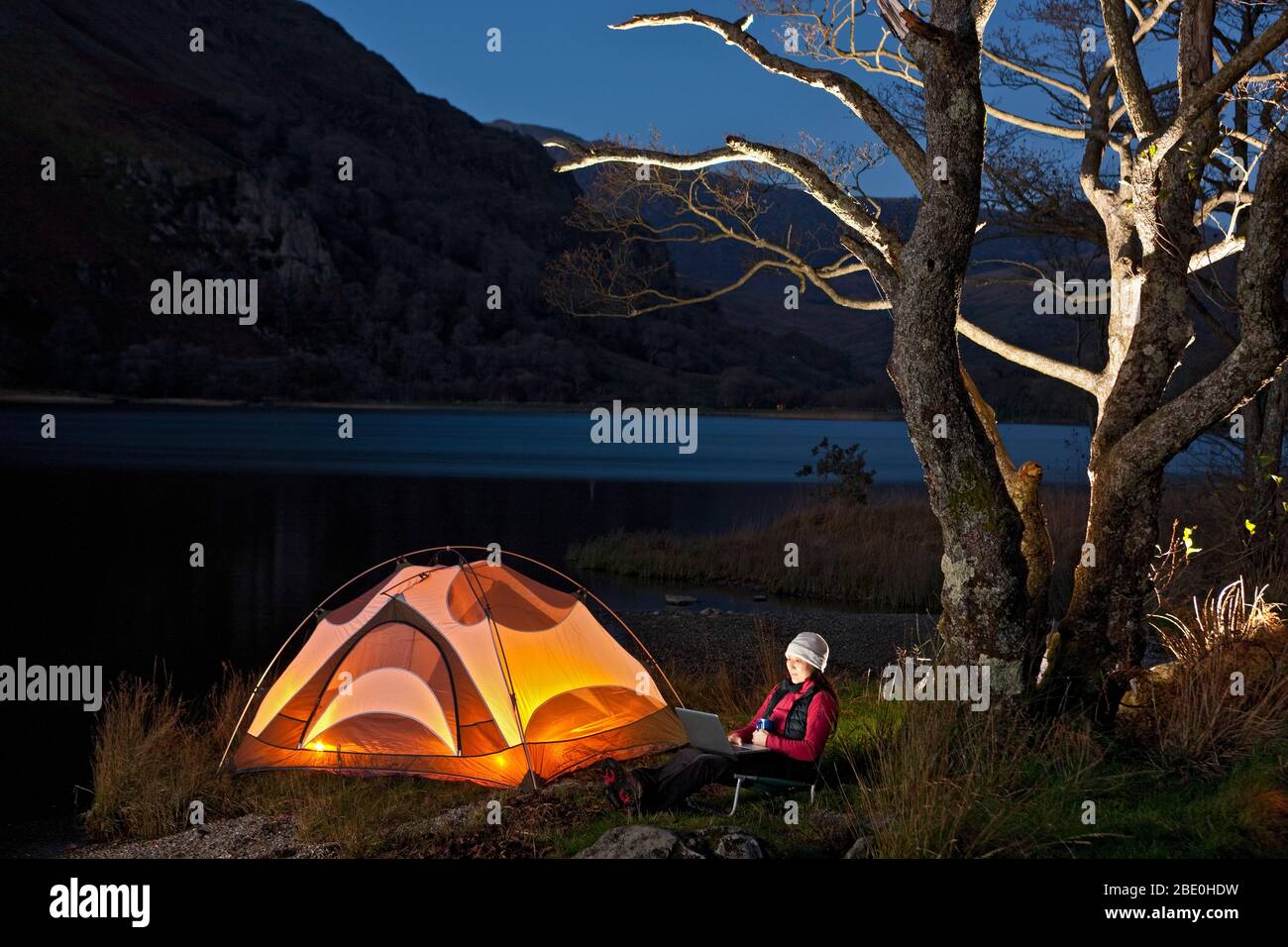 female hiker looking at her laptop at camp in North Wales Stock Photo