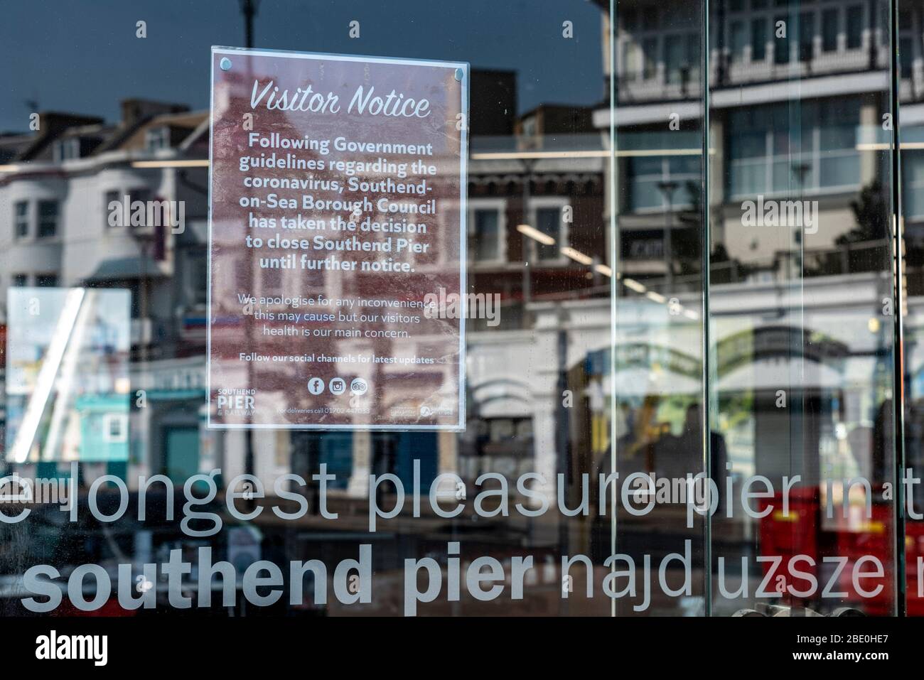 Pier entrance on Southend on Sea seafront on Easter Bank Holiday during COVID-19 Coronavirus pandemic lockdown period. Closed sign with reflection Stock Photo