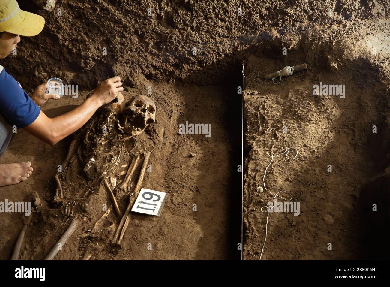 Member of Indonesian archaeology team cleaning up prehistoric Mongoloid skeletons at the Gua Harimau excavation site in Sumatra, Indonesia. Stock Photo