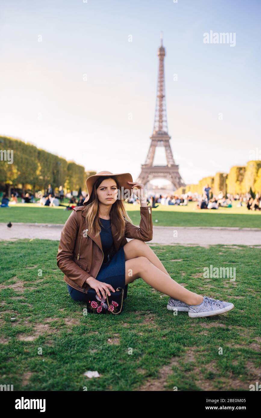 Beautiful girl sitting in Paris against the backdrop of the Eiffel tower  Stock Photo - Alamy