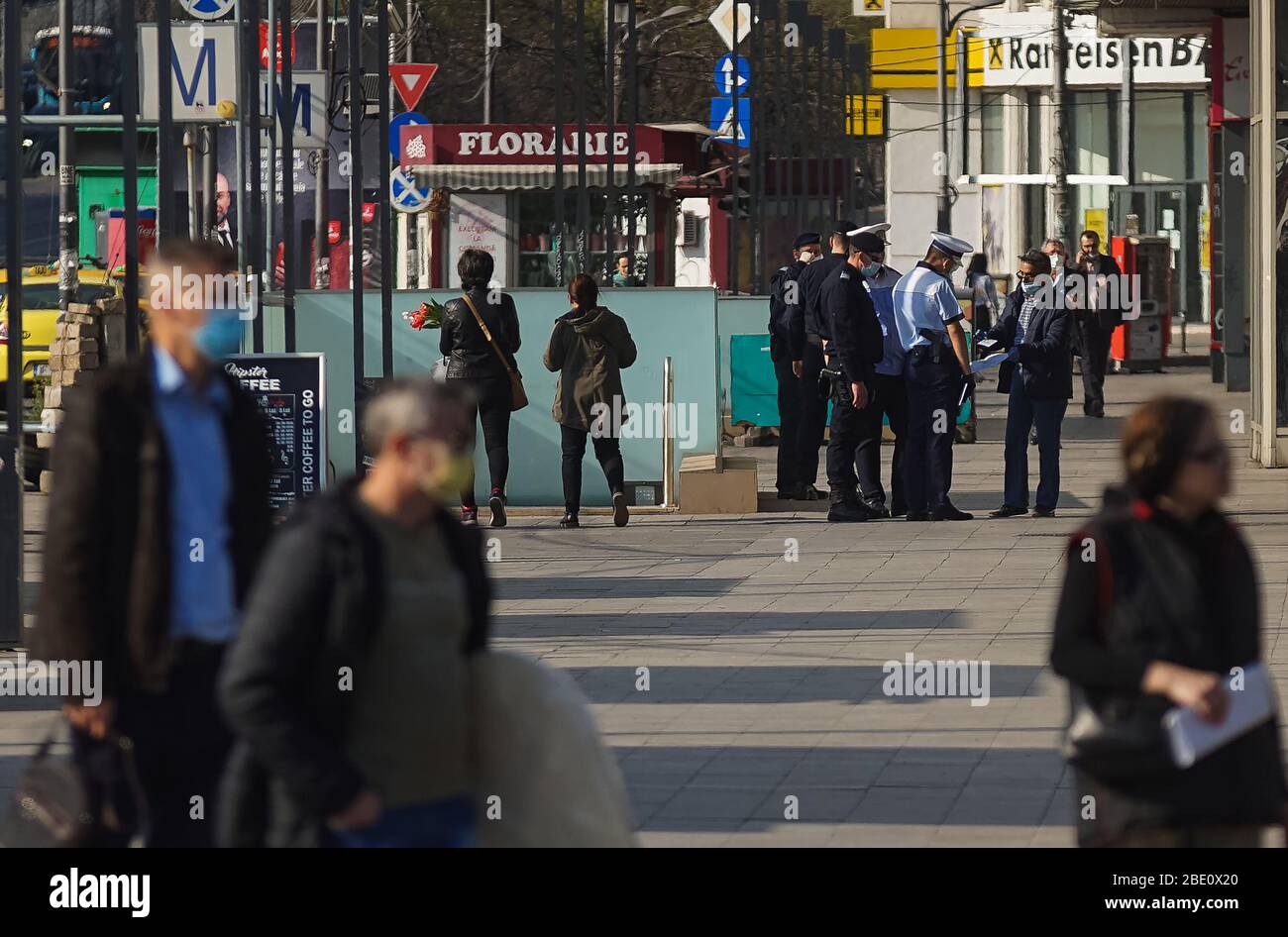 Bucharest, Romania - April 09, 2020: Police officers control people checking whether they had the essential Home Exit certificates. Romania is in lock Stock Photo