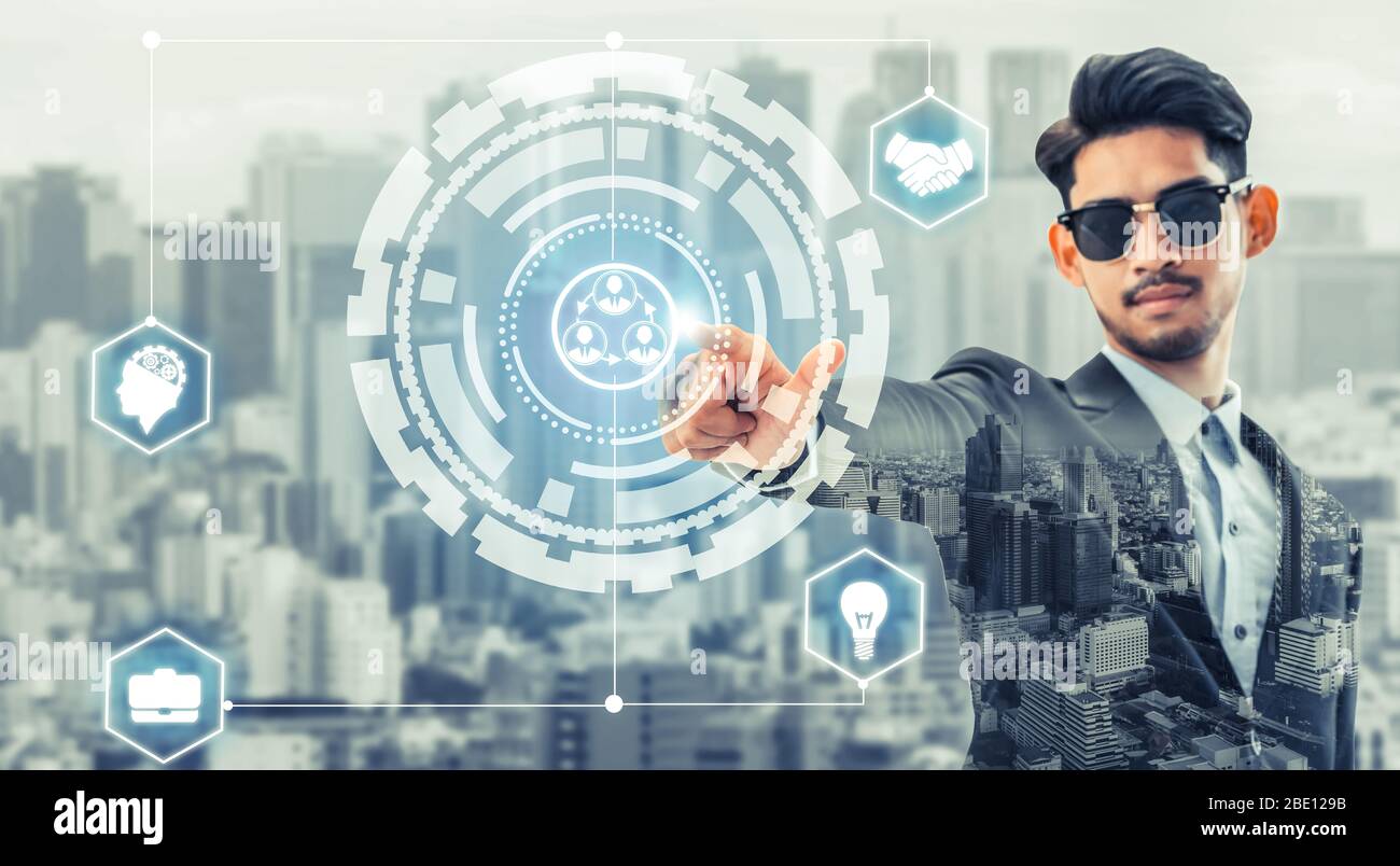Human resource management and recruitment concept - Businessman pointing at people icons with creative strategy design against modern city background. Stock Photo