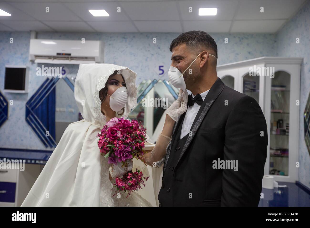 Beijing, Palestinian Deheisheh refugee camp near the West Bank city of Bethlehem. 10th Apr, 2020. Palestinian bride, Shima' al-Titi, adjusts the face mask for her groom, Ishaq Musleh, before they leave the beauty salon in the Palestinian Deheisheh refugee camp near the West Bank city of Bethlehem, on April 10, 2020. Credit: Luay Sababa/Xinhua/Alamy Live News Stock Photo