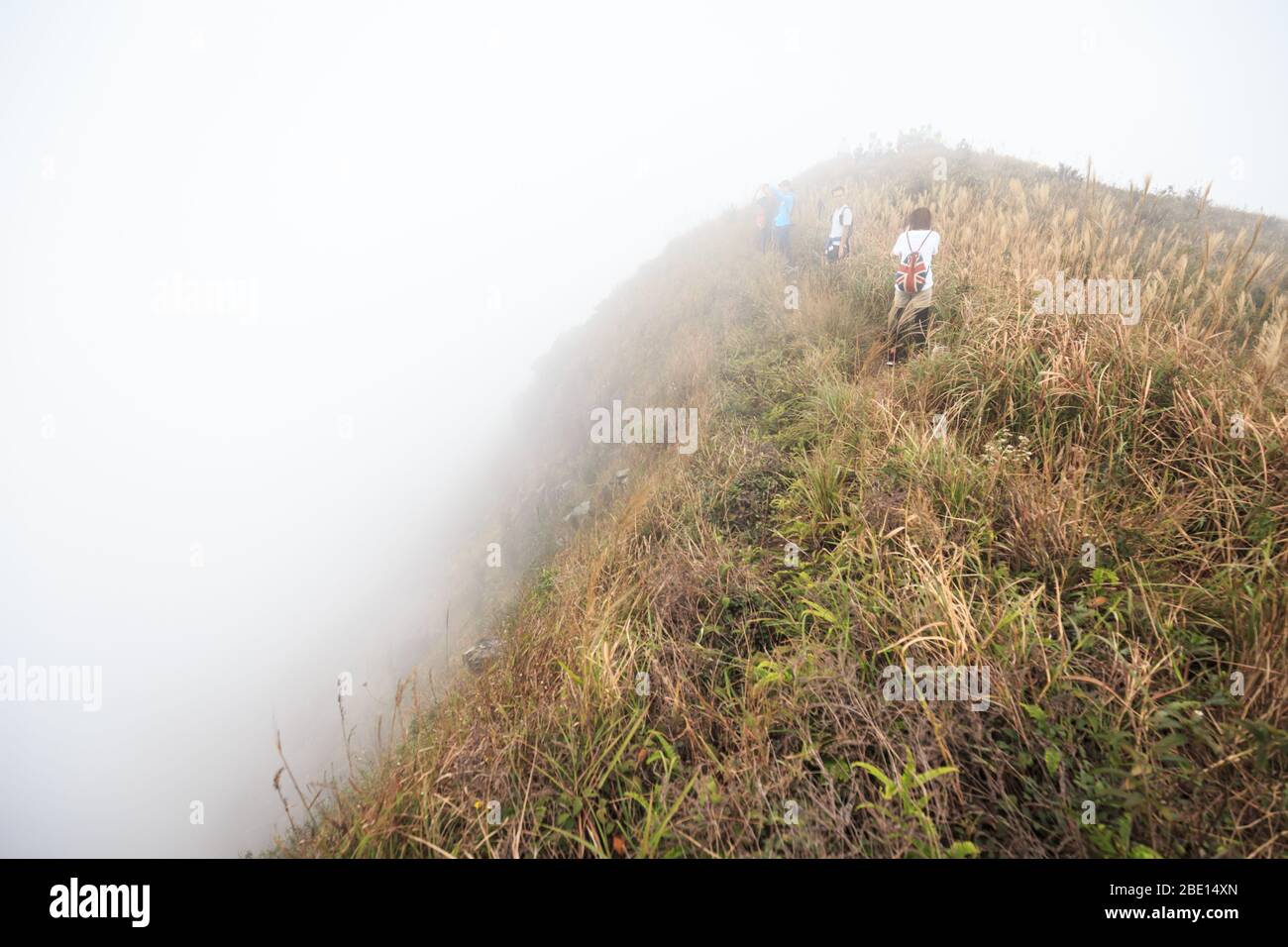 Trekking through the mist at the peak Stock Photo