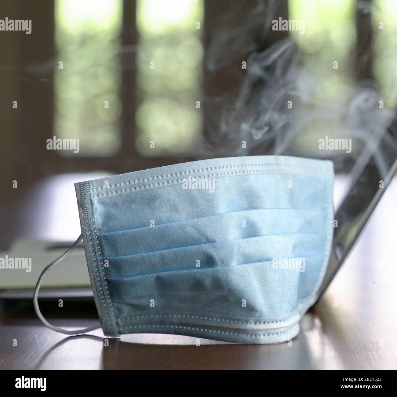 Surgical face mask surrounded by smoke. Protection for bad air